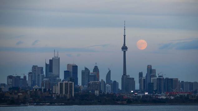 Ang buwan makikita sa likod ng skyline ng lungsod ng Toronto.