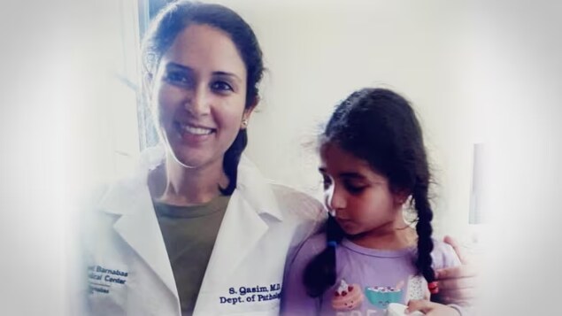 Syeda Qasim, left, with her daughter, wore a doctor’s white coat for the first time after six years as she celebrated her acceptance into a pathology residency in New Jersey in 2021. (Submitted by Syeda Qasim)
