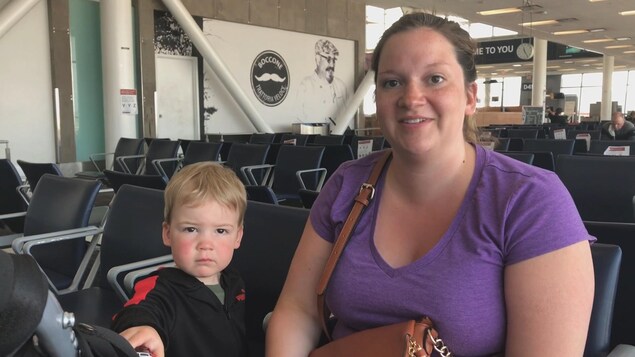 Une femme assise dans une aire de repos dans un aéroport.