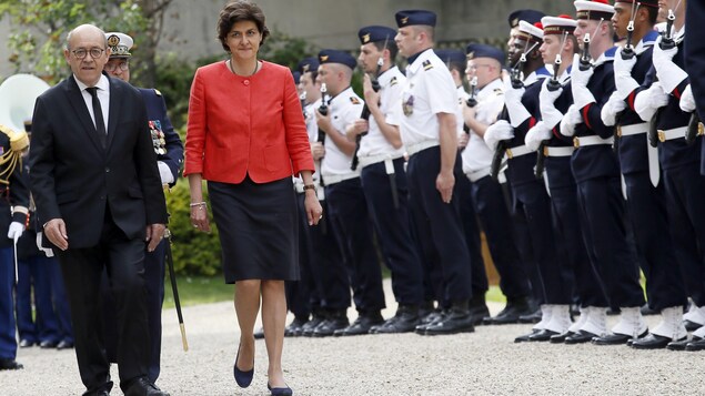 La nouvelle ministre des Armées de la France, Sylvie Goulard, passe en revue la garde d’honneur en compagnie de son prédécesseur, Jean-Yves Le Drian, durant une cérémonie de passation des pouvoirs à Paris le 17 mai 2017.