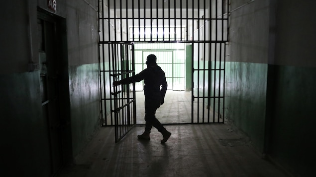 حارس يفتح باب سجن، في 7 كانون الثاني (يناير) 2020، في منطقة الحسكة في شمال شرق سوريا يُحتجز فيه أجانب يشتبه في قتالهم في صفوف تنظيم ’’الدولة الإسلامية‘‘ المسلّح.