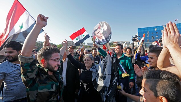 Place des Omeyyades, à Damas, des Syriens brandissent le drapeau national afin de montrer leur appui au régime, samedi matin. Place des Omeyyades, à Damas, des Syriens brandissent le drapeau national afin de montrer leur appui au régime, samedi matin.