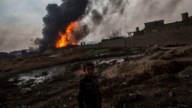 Un enfant irakien devant un puits de pétrole en feu à Al-Qayyarah, près de Mossoul.