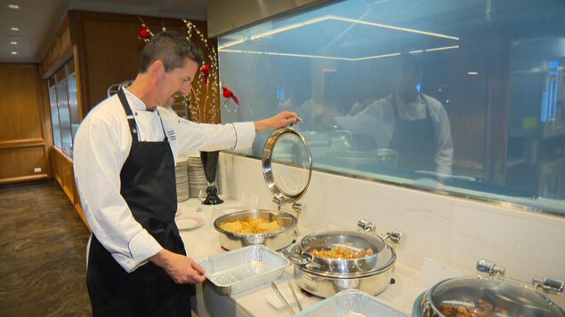 Un cuisiner ouvre un contenant.
