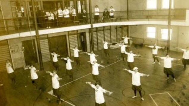 Des étudiantes des arts ménagers lors d'une classe de conditionnement physique dans le gymnase pour femmes du Taché Hall Des étudiantes des arts ménagers lors d'une classe de conditionnement physique dans le gymnase pour femmes du Taché Hall