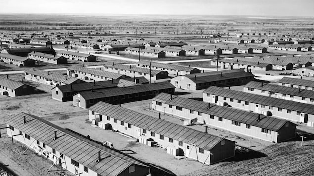 Vue aérienne d'un camp d'internement avec de multiples bâtiments en rangées