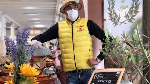 Tao Deliere, derrière son kiosque où il offre différentes variétés d’olives.