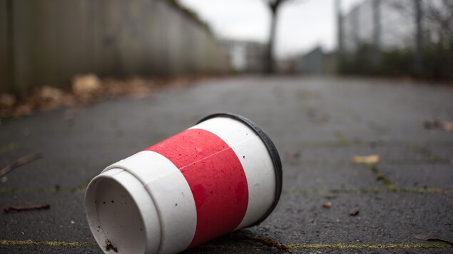 Une tasse à café jetable gît au sol.