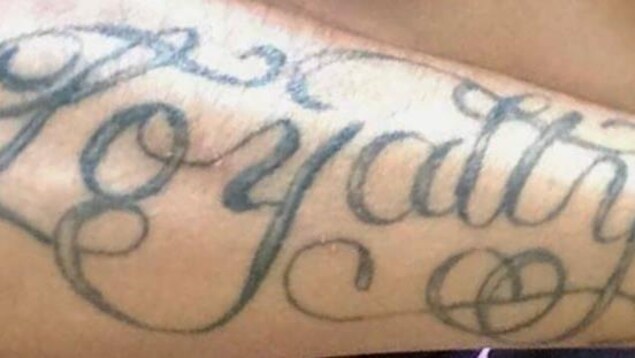Bras portant un tatouage "Loyalty". Bras portant un tatouage "Loyalty".