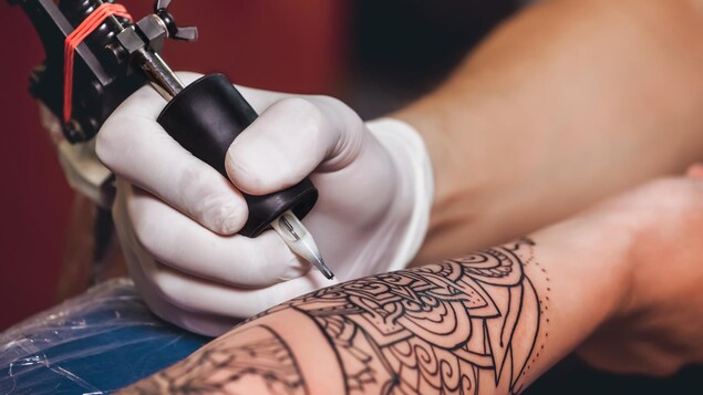 Un gros plan sur le bras d'une personne en train de se faire tatouer. Un gros plan sur le bras d'une personne en train de se faire tatouer.