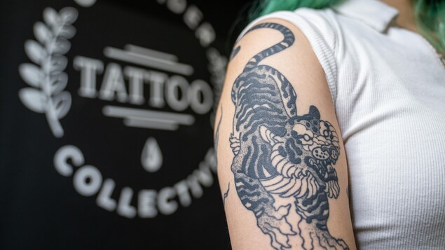 Un tatouage de tigre sur le bras d'une jeune femme.