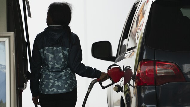Photo: Radio-Canada\ Ivanoh Demers
Une femme remplit sa voiture d'essence à une station-service.