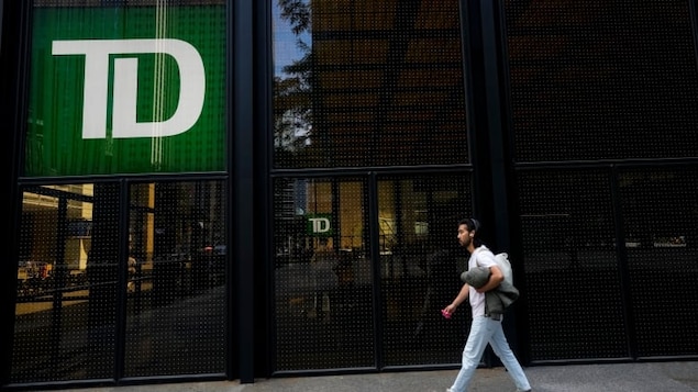 A man walks past the TD Bank in the Bay Street Financial District in Toronto. A former TD Bank employee falsified documents to open dozens of accounts and provided concierge-like services to help cash flow across borders, Bloomberg News reported on Monday.