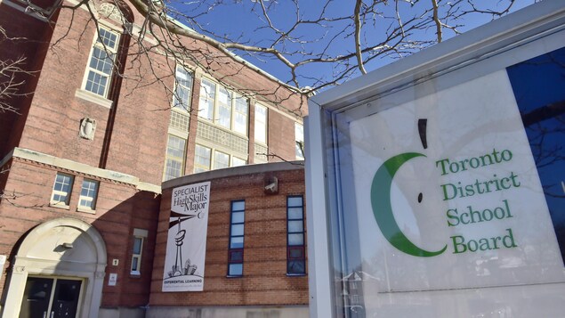 Une enseigne devant un édifice en briques.