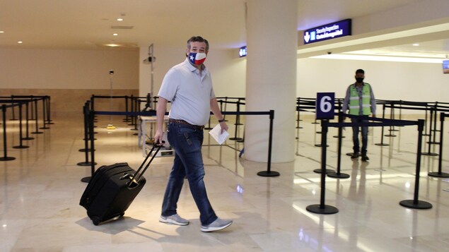 Ted Cruz porte un bagage à roulettes à l'aéroport de Cancún