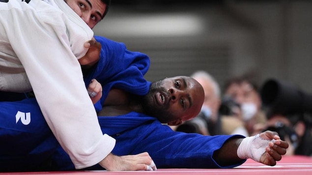 Teddy Riner est maintenu sur le sol par Tamerlan Bashaev.