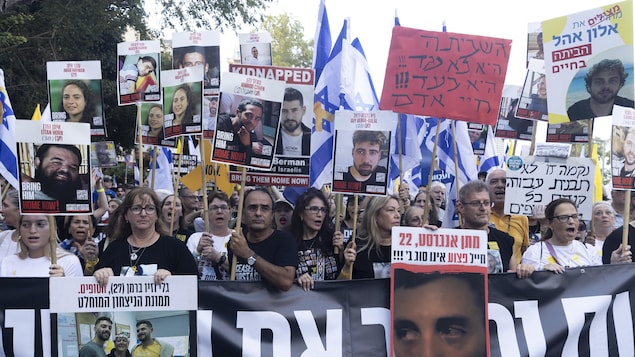 Les familles des otages et leurs sympathisants brandissent des photos des otages lors d'une manifestation appelant à un accord pour leur libération, le 17 août 2025 à Tel-Aviv.