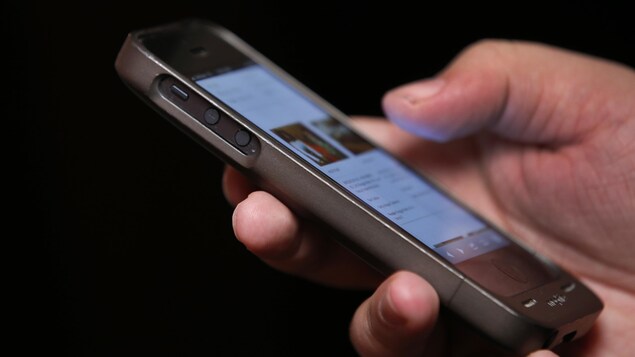 Une main tient un téléphone intelligent.