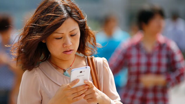 Isang babae na nakatingin sa kanyang smartphone.