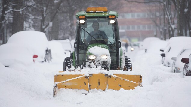Une déneigeuse nettoie une rue de Montréal.