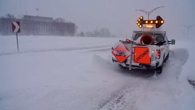 Une voiture de la Ville de Rimouski avec des panneaux inscrits «lentement».