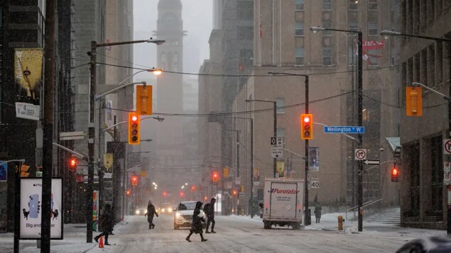 Des piétons dans les rues enneigées de Toronto