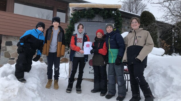 Trois garçons lancent leur kiosque de bonbons