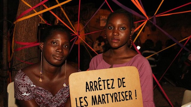 Elles affichent une pancarte avec le message : Arrêtez de les martyriser. Elles affichent une pancarte avec le message : Arrêtez de les martyriser.