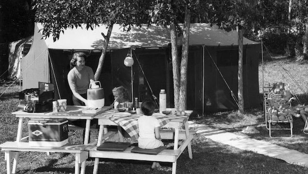 Famille installée avec tente et table à pique-nique sur un terrain de camping au Manitoba.