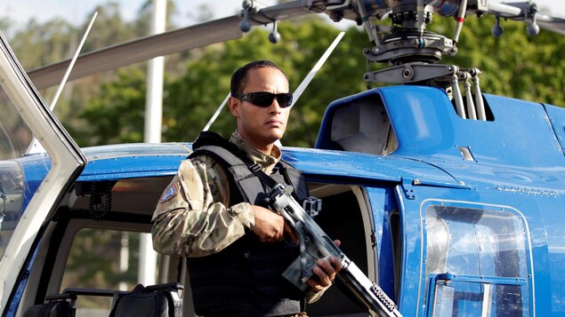 L'agent de police Oscar Perez posant devant un hélicoptère. L'agent de police Oscar Perez posant devant un hélicoptère.