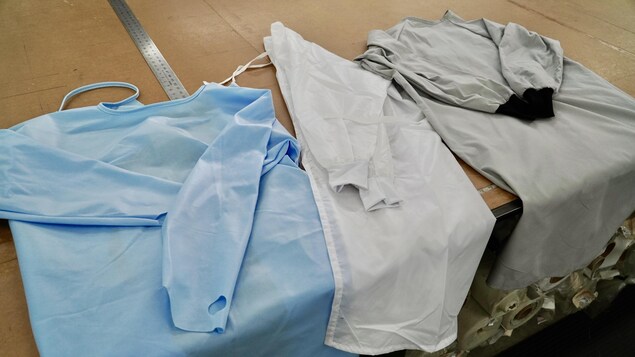 Trois jaquettes de protection étalées sur une table.