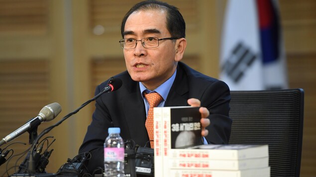 Thae Yong-ho parle dans un micro, devant des exemplaires de ses mémoires. Thae Yong-ho parle dans un micro, devant des exemplaires de ses mémoires.