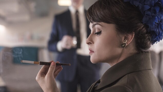 Une femme tient une cigarette dans la main.