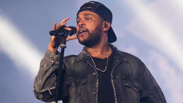 L'homme chante dans un micro.
