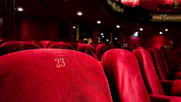 Des fauteuils rouges dans une salle de théâtre.