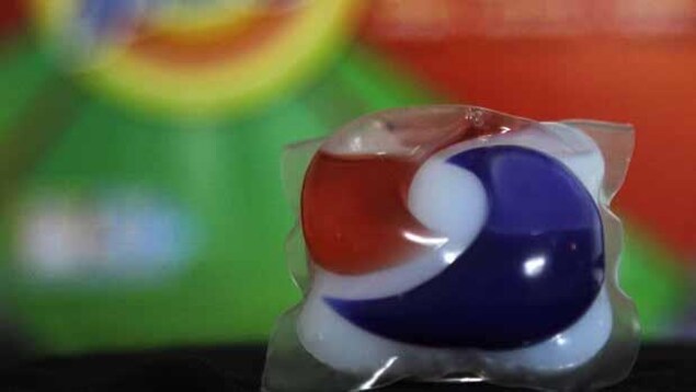 Une capsule de détergent bleue, rouge et blanche.