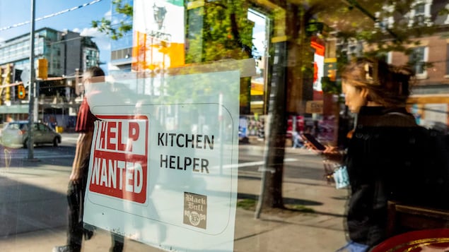 A 'Help Wanted' sign hangs in the window of a bar along Queen Street West in Toronto earlier this summer. Workers have shifted from jobs in the service and food industries to potentially more lucrative positions in other fields, according to data compiled by CBC News.