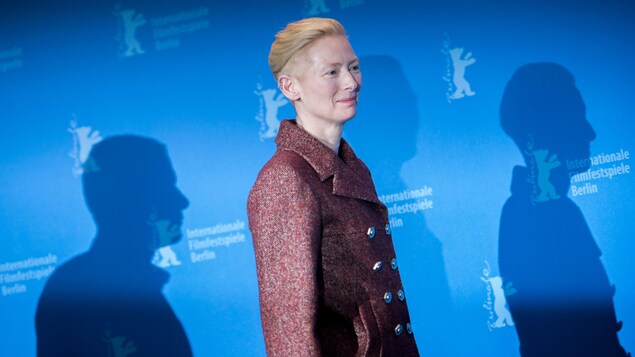 Une femme pose de profil pour des photographes lors d'un événement tapis rouge au festival de film de berlin. 