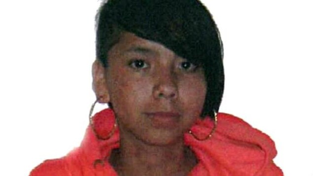 Tina Fontaine porte une frange en diagonale, des anneaux dorés et un chandail à capuchon orange. Tina Fontaine porte une frange en diagonale, des anneaux dorés et un chandail à capuchon orange.