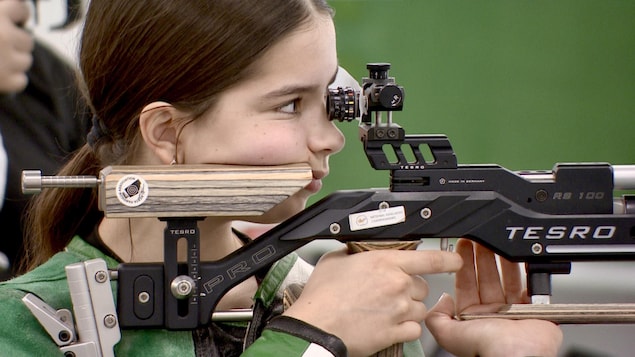 Une jeune fille dans un centre de tir de Saskatoon, en Saskatchewan, s'entraîne au tir sportif, en mai 2025.