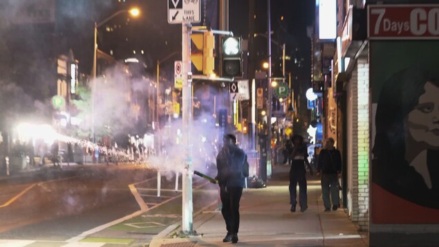 Une personne avec un feu d'artifice à la main.
