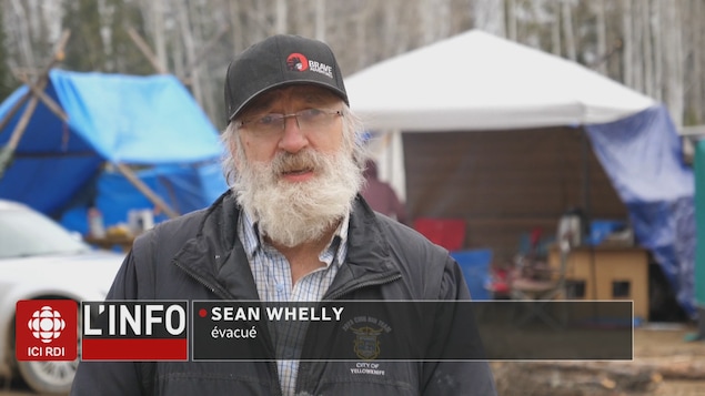 Sean Whelly devant une tente.
