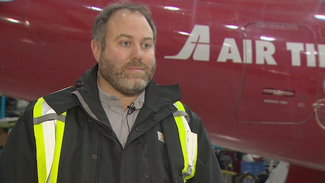 Chris Reynolds devant un avion d'Air Tindi.