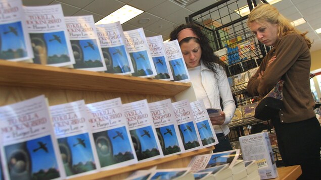 Deux femmes se trouvent à côté d'exemplaires de To Kill a Mockingbird sont exposés dans une librairie à Chicago. Deux femmes se trouvent à côté d'exemplaires de To Kill a Mockingbird sont exposés dans une librairie à Chicago.