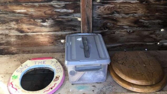 Deux sièges de toilette couvrent deux trous dans des latrines. Deux sièges de toilette couvrent deux trous dans des latrines.