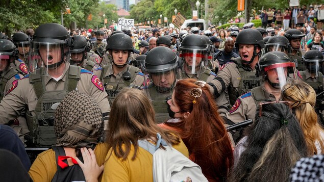 Des policiers antiémeutes devant un groupe d'étudiants pendant une manifestation. 