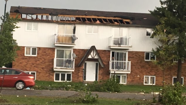 Un bloc d'appartements dont la toiture a été partiellement arrachée par le vent. Un bloc d'appartements dont la toiture a été partiellement arrachée par le vent.