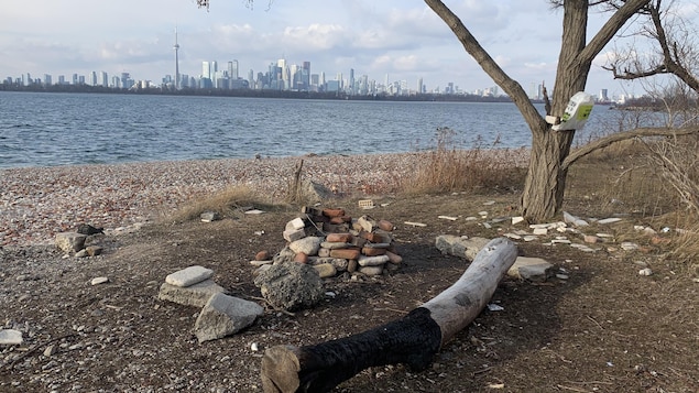 Un emplacement pour faire un feu sur une plage de gravats en bordure du lac Ontario avec une vue sur le centre-ville de Toronto.