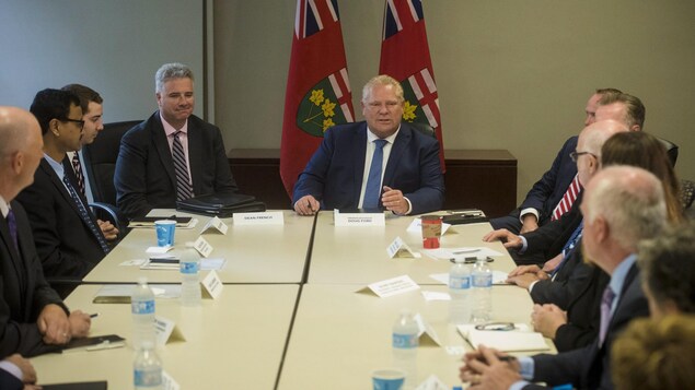 Doug Ford à une table entourée de gens d'affaires Doug Ford à une table entourée de gens d'affaires