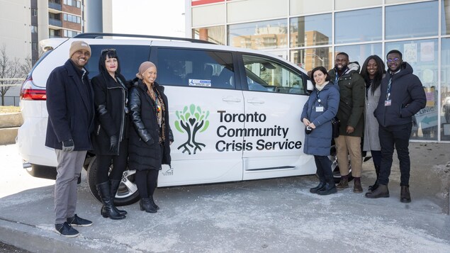 Un groupe pose devant une camionnette du programme Toronto Community Crisis Service